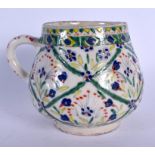 A MIDDLE EASTERN TURKISH KUTAHYA FAIENCE POTTERY WATER CUP painted with foliage and vines. 11 cm x 1