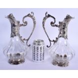 A PAIR OF ART NOUVEAU SILVER PLATED CLARET JUGS overlaid with fish and vines. 27 cm high.