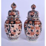 A PAIR OF 19TH CENTURY JAPANESE MEIJI PERIOD IMARI VASES AND COVERS of ribbed form. 30 cm high.