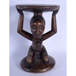 A LARGE AFRICAN TRIBAL CARVED WOOD FERTILITY STOOL modelled upon a circular base. 43 cm x 23 cm.
