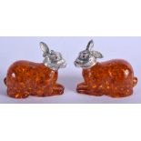 A PAIR OF SILVER AND AMBER HARES. 6 cm x 4 cm.