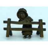 A small gilt bronze figure of a girl leaning on a fence 10 x 7cm.