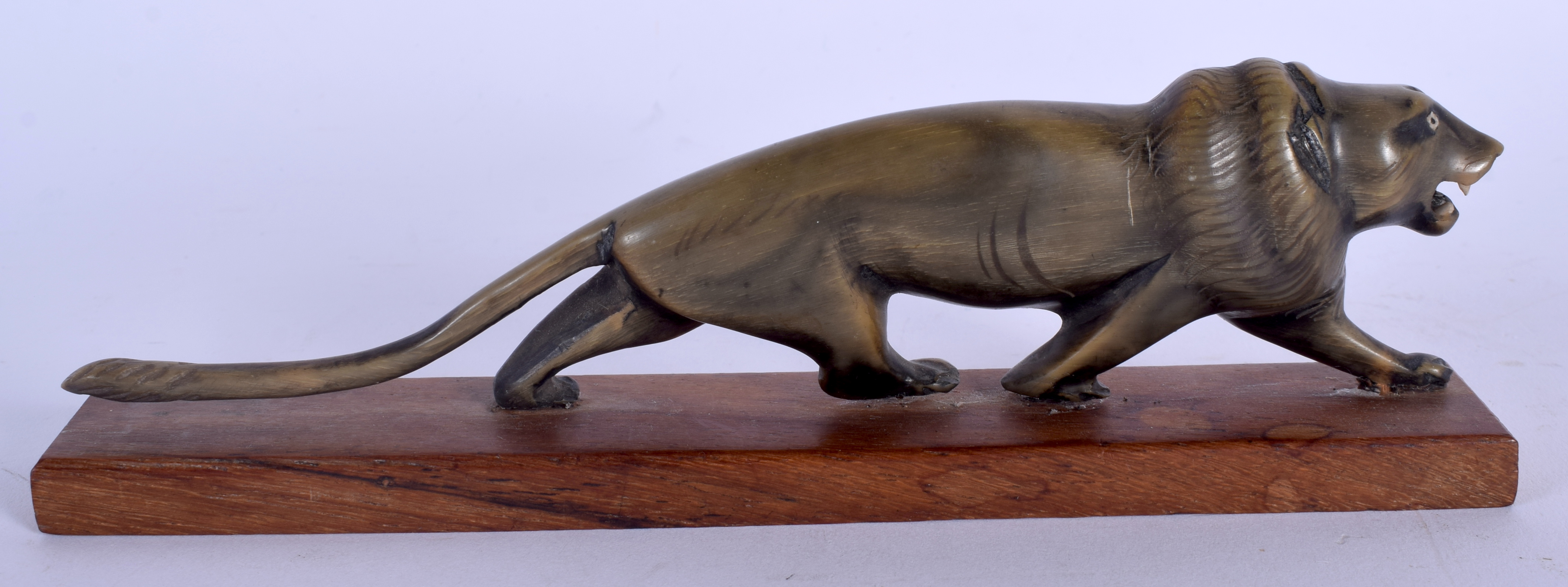 A 19TH CENTURY MIDDLE EASTERN CARVED RHINOCEROS HORN FIGURE OF A ROAMING LION modelled upon a wooden - Image 2 of 2