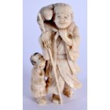 A 19TH CENTURY JAPANESE MEIJI PERIOD CARVED IVORY OKIMONO modelled as a male beside a child. 10 cm x