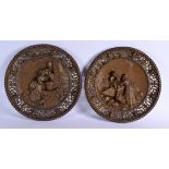 A LARGE PAIR OF ANTIQUE BRONZE CIRCULAR WALL PLAQUES decorated with figures in various pursuits. 37
