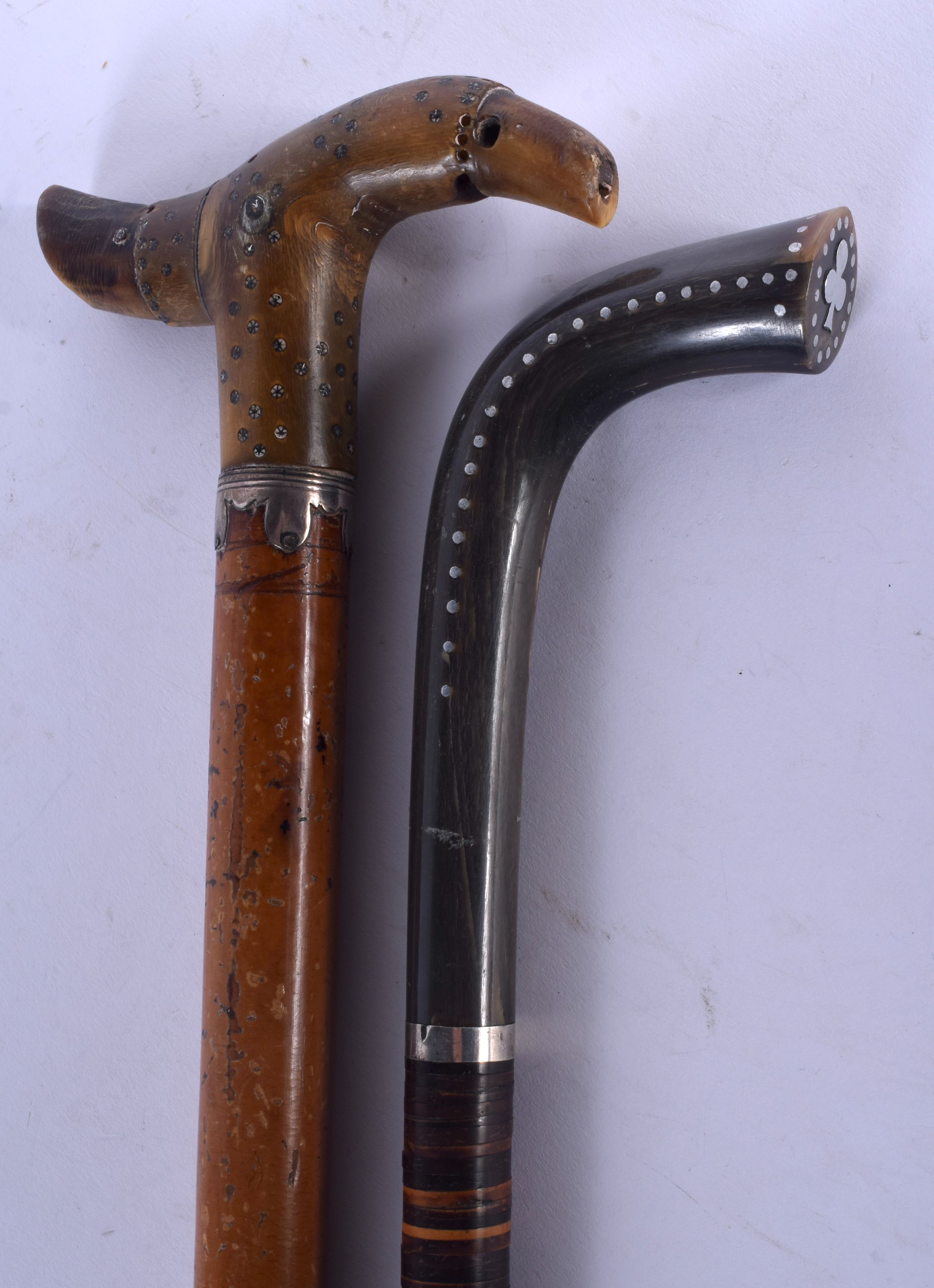 TWO 19TH CENTURY CONTINENTAL CARVED RHINOCEROS HORN HANDLED WALKING CANES with silver pique work han