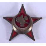 AN UNUSUAL MIDDLE EASTERN BRASS AND ENAMEL STAR BADGE. 4.5 cm wide.
