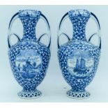 A pair of Delft twin handle vases painted with scenes of Dutch barges. 25cm.