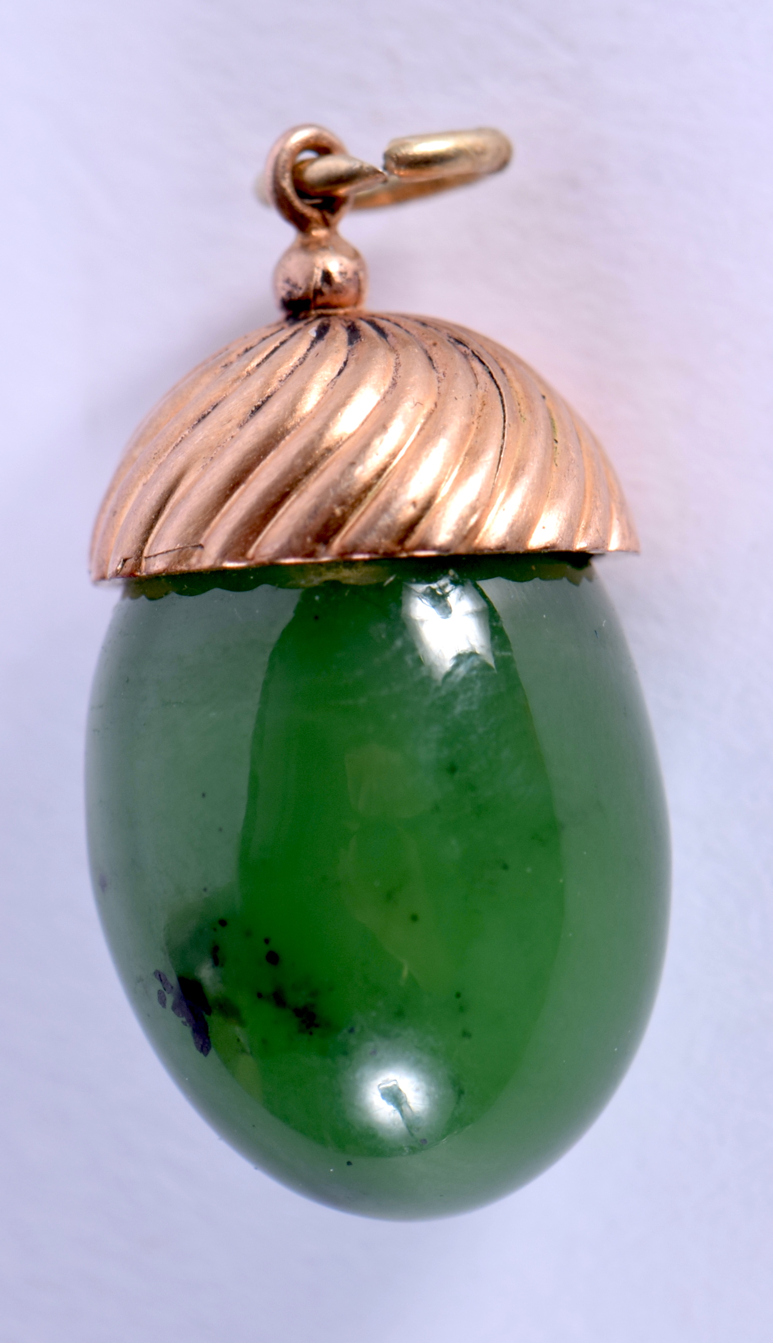 AN ANTIQUE CONTINENTAL GOLD AND JADEITE EASTER EGG PENDANT. 1.5 cm x 1 cm.