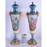 A LARGE PAIR OF CONTINENTAL SEVRES STYLE PORCELAIN VASES AND COVERS painted with figures within land