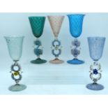 A SET OF FIVE VENETIAN COLOURED GLASS GOBLET CUPS with foliate stems. Largest 24 cm high. (5)