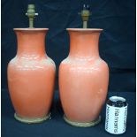 A PAIR OF EARLY 20TH CENTURY CHINESE PEACH BLOOM CORAL GROUND VASES converted to lamps. Porcelain 32