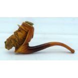 A 19TH CENTURY CARVED MEERSCHAUM AND AMBER PIPE formed as a bearded male. 11.5 cm wide.