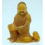 A CHINESE CARVED SOAPSTONE FIGURE OF A LUOHAN 20th Century, modelled in draped robes resting both ha