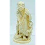 A 19TH CENTURY JAPANESE MEIJI PERIOD CARVED IVORY OKIMONO modelled as a father and son. 10 cm high.