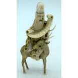 A 19TH CENTURY JAPANESE MEIJI PERIOD CARVED IVORY OKIMONO modelled holding a scroll upon a deer. 10