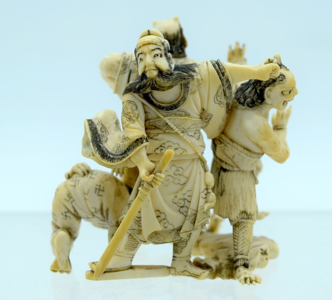 A 19TH CENTURY JAPANESE MEIJI PERIOD CARVED IVORY OKIMONO modelled as numerous oni in various pursui