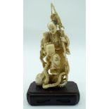 A 19TH CENTURY JAPANESE MEIJI PERIOD CARVED IVORY OKIMONO modelled as a fisherman standing upon an o