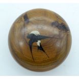 AN ANTIQUE OLIVEWOOD CIRCULAR BOX AND COVER decorated with swallows. 8 cm diameter.