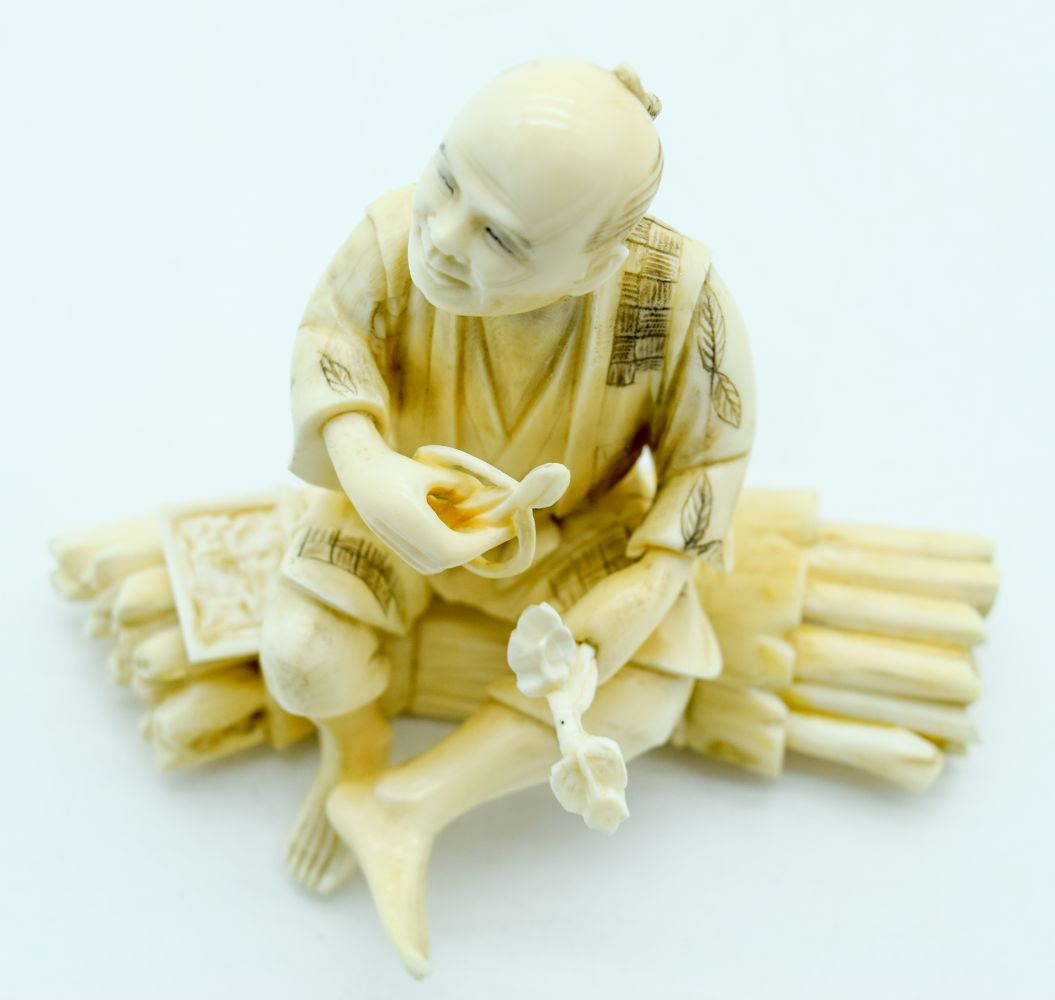 A 19TH CENTURY JAPANESE MEIJI PERIOD CARVED IVORY OKIMONO modelled as a male upon logs holding veget - Bild 7 aus 7