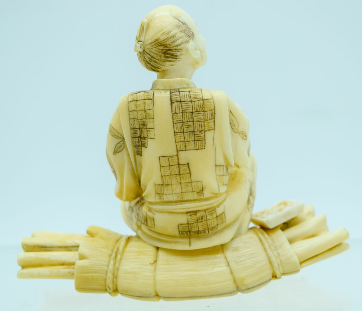 A 19TH CENTURY JAPANESE MEIJI PERIOD CARVED IVORY OKIMONO modelled as a male upon logs holding veget - Bild 3 aus 7