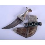 A 19TH CENTURY MIDDLE EASTERN OMANI CARVED RHINOCEROS HORN HANDLED JAMBIYA DAGGER overlaid in silver