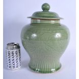 A 19TH CENTURY CHINESE CELADON VASE AND COVER Late Qing, decorated with fish and foliage. 30 cm x 15