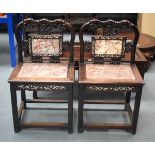 A PAIR OF 19TH CENTURY CHINESE CARVED HARDWOOD MARBLE INSET SEATS decorated with dragons. 94 cm x 55