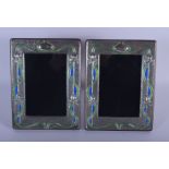 A PAIR OF SILVER AND ENAMEL PHOTOGRAPH FRAMES. 21 cm x 16 cm.