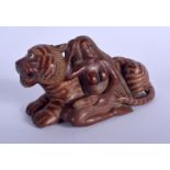 A JAPANESE CARVED BOXWOOD OKIMONO modelled as a tiger and female. 11 cm x 6 cm.