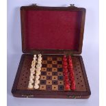AN ANTIQUE CARVED AND STAINED TRAVELLING CHESS SET. 15 cm x 12 cm.