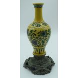 A Chinese yellow ground vase on a bronze embossed stand decorated with foliage 27cm.