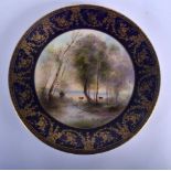 Royal Worcester plate painted with cattle beside a lake beneath a blue and gilt border by George Eva