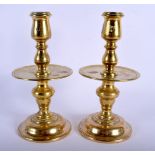 A PAIR OF 18TH CENTURY EUROPEAN BRASS CANDLESTICKS with circular drip trays. 23 cm high.