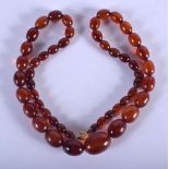 A VINTAGE AMBER TYPE NECKLACE. 31 grams. 56 cm long, largest bead 1.5 cm x 1 cm.