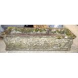 A large cast stone rectangular plater decorated with cherubs 34 x 126 x 37cm.