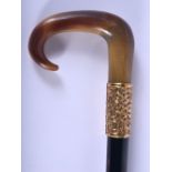 A 19TH CENTURY CONTINENTAL CARVED BUFFALO HORN HANDLED WALKING CANE with yellow metal repousse handl
