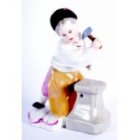 A 19TH CENTURY MEISSEN PORCELAIN FIGURE OF A YOUNG BOY modelled holding aloft a hammer upon a shaped