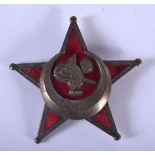 AN UNUSUAL MIDDLE EASTERN BRASS AND ENAMEL STAR BADGE. 4.5 cm wide.