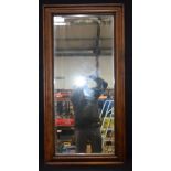 A large wooden framed mirror with bevelled glass 60 x 121cm.