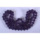 A STRING OF AMETHYST BEADS. 66 cm long.