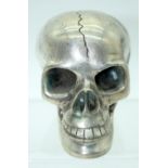 A small metal skull with a reticulated jaw.12 x 10cm .