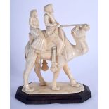 A 19TH CENTURY MIDDLE EASTERN CARVED IVORY FIGURE OF A ROAMING CAMEL modelled with two attendants. 1