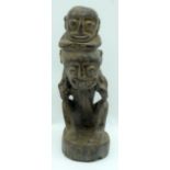 A Nigerian wooden figure of a child on a mans shoulders 17cm.