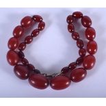 A VINTAGE CHERRY AMBER BAKELITE NECKLACE. 53 grams. 48 cm long, largest 2.5 cm wide.