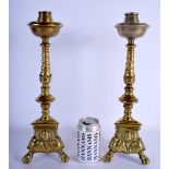 A PAIR OF 18TH CENTURY BRASS ECCLESIASTICAL CANDLESTICKS decorated with mask heads. 39 cm high.