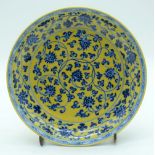 A Chinese yellow ground dish decorated with foliage 23cm.