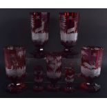 SEVEN ANTIQUE BOHEMIAN RUBY GLASS GOBLET BEAKERS decorated with deer. Largest 18.5 cm high. (7)