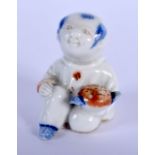 A 19TH CENTURY JAPANESE MEIJI PERIOD HIRADO PORCELAIN FIGURE OF A BOY modelled holding a vegetable.