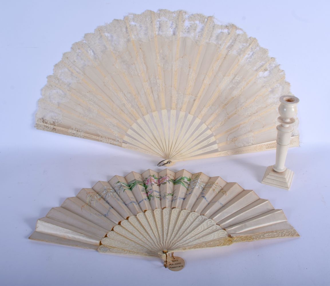 TWO ANTIQUE IVORY FANS and a candlestick. Largest 40 cm extended. (3)